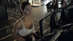 'Attractive fitness woman walking on treadmill for cardio training in gym club'